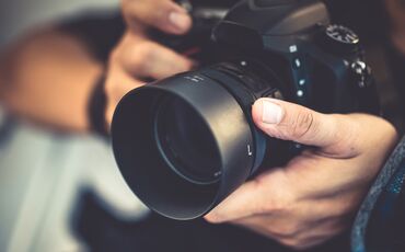 Ansicht auf die Hände eines Mannes, der Fotos macht.