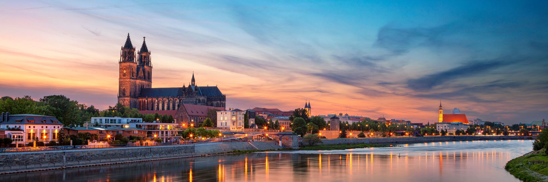 Skyline von Magdeburg im Abendlicht. Im Hintergrund sieht man unter anderem den Dom.